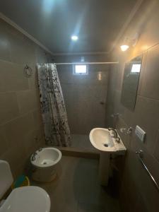 a bathroom with a toilet and a sink at Alquiler temporario Ruta 3 in Azul
