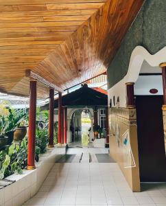 a hallway of a building with a wooden ceiling at d'BACA Homestay in Batu