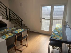 a room with a table with chairs and a staircase at AEROHOSTEL Brasil in Guarulhos