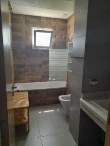 a bathroom with a tub and a toilet and a window at perla Saïdia in Saidia 