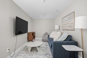 Una sala de estar con un sofá azul y un televisor. en Sleeps 22-Downtown Westfield-Near Grand Park!, en Westfield