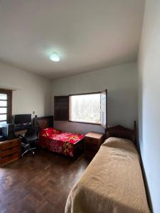 a bedroom with a bed and a desk and a window at República Os Bartira in Ouro Preto
