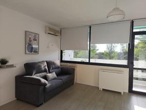 a living room with a couch and a large window at Estudio Taupe in Matalascañas