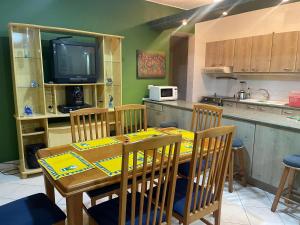 a kitchen with a table with chairs and a television at Playa Almedro RESORT in Volcán Chimborazo