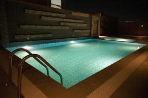 a swimming pool on top of a building at night at Jadeel Hotel in Al Khobar