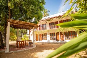 Casa Triz في بويرتو إسكونديدو: مبنى امامه طاولة وكراسي