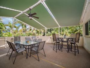 a patio with tables and chairs and a ceiling fan at Aloha Aku Ohana2 Suite - Relaxing Garden Views Await in Kihei