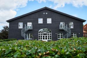 Una casa negra con ventanas blancas y escaleras. en Danhostel Haderslev, en Haderslev