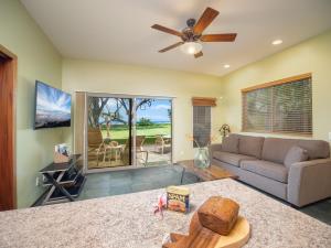 un salon avec un canapé et un ventilateur de plafond dans l'établissement Aloha Aku CoCoPalm2 Suite - Your Cozy Beachfront Escape, à Kihei