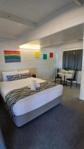a bedroom with a large white bed and a table at Kaputar Motel in Narrabri +58 photos