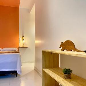 una habitación con una cama y un oso de madera en un estante en Morada da Lena - Praia do Forte, en Farol 11 fotos más