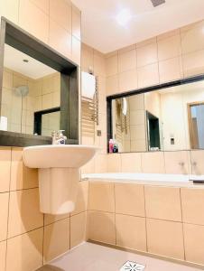 a bathroom with a sink and a mirror and a tub at High Apartment in St James-Piccadilly COV10 in London