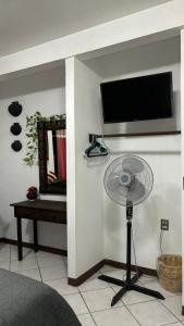 a room with a fan and a tv on a wall at Casa los Arcos Oaxaca in Oaxaca City +31 photos