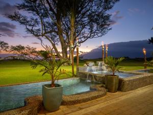 une piscine avec deux plantes en pot et une fontaine dans l'établissement Aloha Aku CoCoPalm Suite - Experience Tropical Bliss, à Kihei