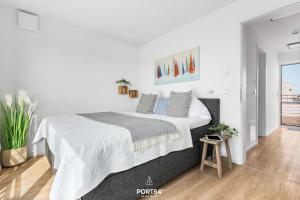 a white bedroom with a large bed in it at Ferienhaus Saltkrokan Olpenitz in Olpenitz