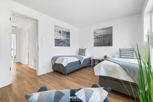 two beds in a bedroom with white walls at Ferienhaus Saltkrokan Olpenitz in Olpenitz +25 photos