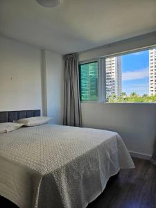 Un dormitorio con una cama y una ventana grande. en Apartamento um quarto Ilha Pura, Rio Centro, próx Parque Olímpico, en Río de Janeiro