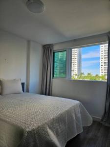 Un dormitorio con una cama y una ventana grande. en Apartamento um quarto Ilha Pura, Rio Centro, próx Parque Olímpico, en Río de Janeiro 39 fotos más
