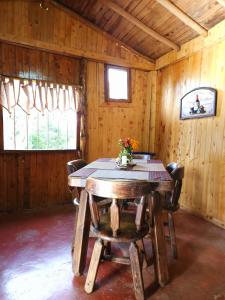 a dining room with a wooden table and chairs at Casa De Campo "Las Chispas" in Medellín