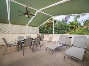 a patio with a table and chairs and a ceiling at Aloha Aku Ohana Suite - Spacious Garden View Oasis in Kihei