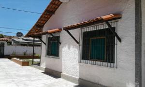 a white building with two barred windows on it at Casa de praia in Buzios +5 photos