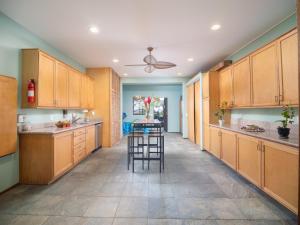 a large kitchen with wooden cabinets and a table at Aloha Aku Ohana Suite - Spacious Garden View Oasis in Kihei