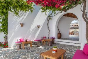 a patio with pink furniture and flowers at Aegeo Hotel in Chora Folegandros
