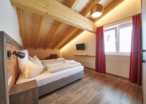 sypialnia z łóżkiem w pokoju z drewnianym sufitem w obiekcie Appartements Liebe Heimat w Saalbach Hinterglemm
