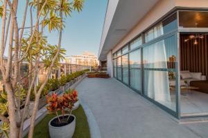 - un balcon dans un bâtiment avec des palmiers dans l'établissement Nosso Apê 915: Ar-Cond | Acad.| Piscina - NA0904, à Juiz de Fora