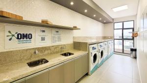 une grande cuisine avec lave-linge et sèche-linge dans l'établissement Nosso Apê 915: Ar-Cond | Acad.| Piscina - NA0904, à Juiz de Fora