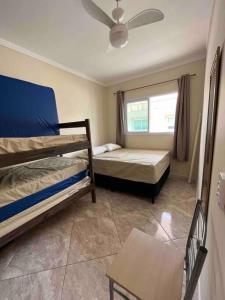 a bedroom with two bunk beds and a window at Apartamento completo com wi-fi e piscina in Ubatuba