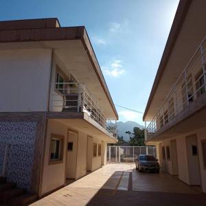 a building with a car parked in a parking lot at Apartamento completo com wi-fi e piscina in Ubatuba