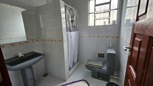 a bathroom with a sink and a toilet and a window at Casa de praia in Buzios
