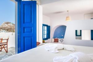 a bedroom with a blue door and a bed at Aegeo Hotel in Chora Folegandros