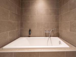 a bath tub with a shower in a bathroom at Waterside Elegance Retreat in Antoing +32 photos