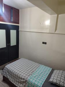 a bedroom with a bed with a blue and white blanket at Appartement immobilier à Fès in Ville Nouvelle +5 photos