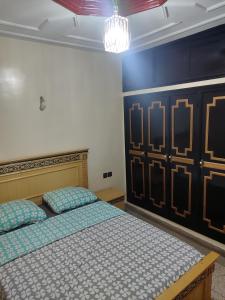 a bedroom with a bed and a chandelier at Appartement immobilier à Fès in Ville Nouvelle