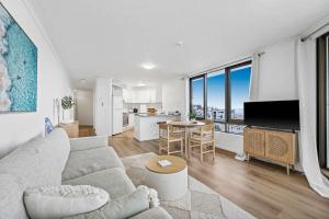 Una sala de estar con un sofá y una ventana grande. en Pearl By Khove, en Gold Coast