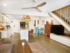 a kitchen and a living room with a ceiling fan at Elanora 3 bedroom apartment in Gold Coast