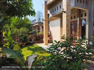 a house with a yard with plants in front of it at Villa East Muria in Gunungwungkal