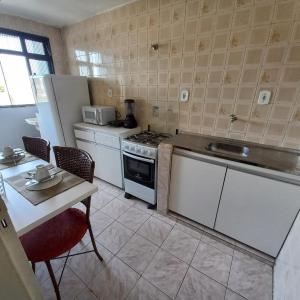 a kitchen with a stove and a refrigerator and a table at Apartamento 2 quartos Asa Norte com cozinha excelente localização in Brasilia +9 photos