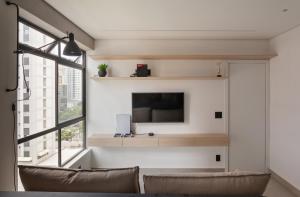 a living room with a tv and a couch at Apartamento Loft Novíssimo in Belo Horizonte