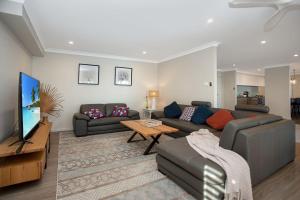 a living room with a couch and a tv at Keera House on Heros Bay in North Arm Cove