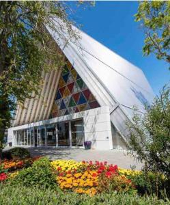 a building with a bunch of flowers in front of it at 4 Minutes walk to Riverside Market!4bed 4 bath in Christchurch
