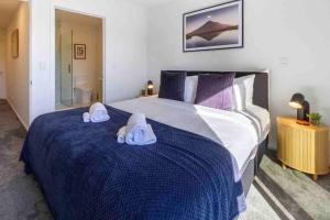 a bedroom with a large bed with towels on it at 4 Minutes walk to Riverside Market!4bed 4 bath in Christchurch