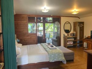 una camera da letto con un letto, una sedia e uno specchio di Potters Cottage a Bellingen
