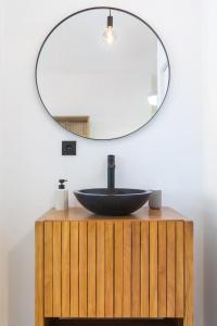 een badkamer met een zwarte wastafel en een spiegel bij Oporto Charming Studio Gaia in Vila Nova de Gaia