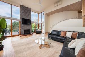 Una sala de estar con un sofá negro y una chimenea. en Cedar Views in McCrae, en McCrae