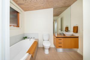 Un baño con bañera, inodoro y lavabo. en Cedar Views in McCrae, en McCrae