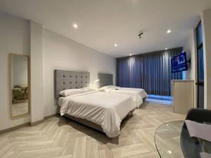 a bedroom with a large bed and a glass table at Moderno Apto Estudio 02 in Cajamarca